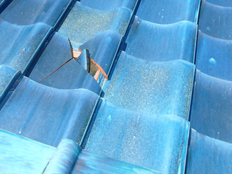 墨田区　瓦の飛散による金属屋根の穴あき　他にも割れた箇所がある