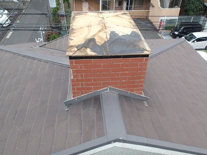 飾り煙突の天板が風で飛ばされて下の合板が露出している状態
