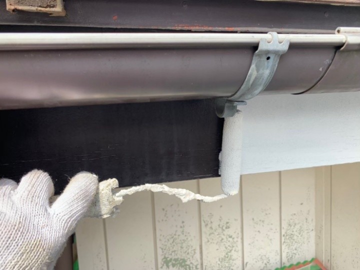 軒天や破風板などの付帯部分もローラーを使って塗装する作業工程