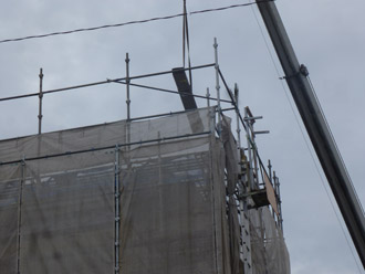 千葉県 八千代市 ビルのR屋根リフォーム、カバー工法　クレーンでガルバリウム鋼板運搬中